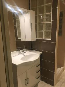Appartement de la nation 1 في لاتور-دو-بين: حمام مع حوض أبيض ومرآة