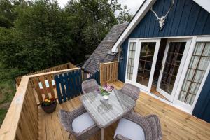 a patio with a table and chairs on a deck at Tanar View in Aboyne