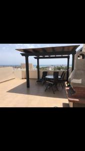 a patio with a table and chairs on a roof at Atico con piscina privada y vistas al mar in Vera