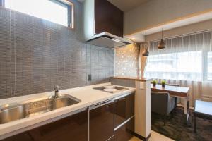 a kitchen with a sink and a counter with a table at R&Run Kyoto Serviced apartment & Suites - Vacation STAY 93241 in Kyoto
