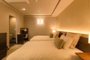 a hotel room with two beds and a television at R&Run Kyoto Serviced apartment & Suites - Vacation STAY 93241 in Kyoto