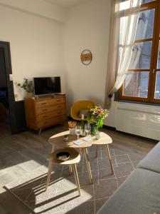 una sala de estar con una mesa con flores. en joli appartement quartier historique, 5 pers, en Moulins