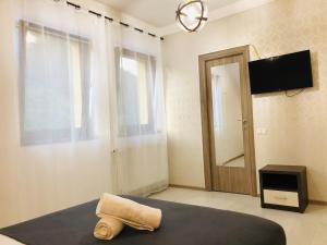 Un dormitorio con una cama y un televisor y una ventana. en SWEET HOUSES VILLa, en Brasov