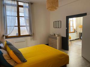 Un dormitorio con una cama amarilla y una ventana en joli appartement quartier historique, 5 pers, en Moulins