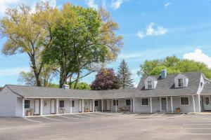 um grande edifício branco com estacionamento em Seneca Clipper Inn em Watkins Glen