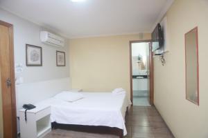 Un pat sau paturi într-o cameră la Campos Gerais Hotel