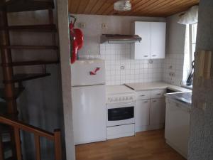 uma cozinha com um frigorífico branco e armários brancos em Ferienhaus Börsengasse 1 em Duderstadt