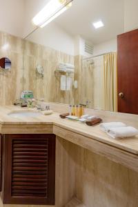 a bathroom with a sink and a large mirror at GHL Hotel Lago Titicaca in Puno