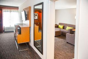 Habitación de hotel con espejo y sala de estar. en Extended Stay America Suites Springfield, en Springfield