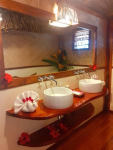 Baño con 2 lavabos y espejo en Oneta Resort, en Ono Island