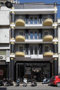 duży budynek z motocyklami zaparkowanymi przed nim w obiekcie Pietra Mare Suites w mieście Patras