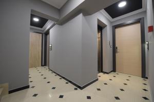 - un couloir avec des portes et du carrelage dans l'établissement Pietra Mare Suites, à Patras