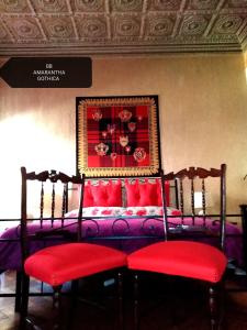sypialnia z fioletowym łóżkiem z czerwonymi poduszkami w obiekcie B&B Amarantha Gothica Genoa w Genui