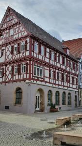a large building with a red and white at Quartier "Zur Alten Apotheke" in Brackenheim