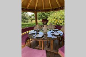 a table on a porch with an umbrella at ROSE COTTAGE in Rowlands Castle