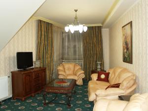 a living room with two chairs and a tv at Atrium Hotel in Ivano-Frankivsʼk