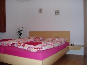ein Schlafzimmer mit einem Bett mit einer rosa Decke in der Unterkunft T Zommerhuuske in De Lutte