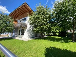 uma casa com varanda e um quintal com árvores em Elinas Mountain Views em Kaprun