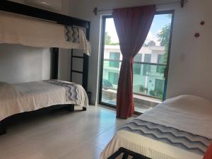 a bedroom with two beds and a large window at Casa Mango in Valladolid +46 photos