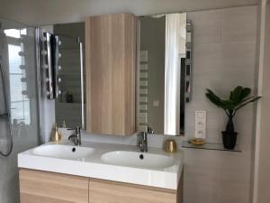 a bathroom with two sinks and a mirror at Résidence Austerlitz centre Angouleme in Angoulême