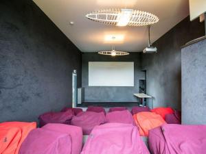 une chambre avec des chaises roses devant un écran dans l'établissement Holiday Home in Den e halfway between Namur and Charleroi, à Denée