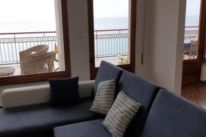 ein blaues Sofa mit zwei Kissen im Wohnzimmer in der Unterkunft #southworking - Appartamento in villa sulla spiaggia a Soverato in Soverato Marina