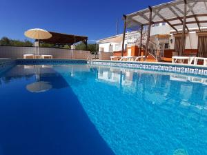 una gran piscina azul con sombrilla en Casa Pino Solo, en Iznájar