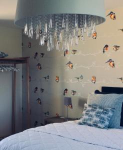 a bedroom with a wall with birds on it at Kingfisher Nook at Waveney Farm in Hoxne