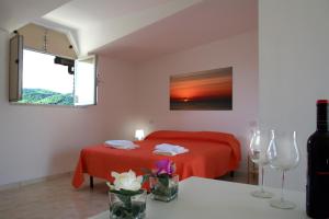 1 dormitorio con cama roja y manta roja en B&B SELENE en Castelnuovo Cilento