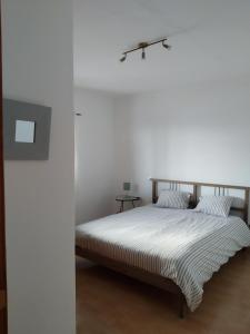 1 cama en un dormitorio con una pared blanca en Can Blum en La Asomada