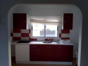 a kitchen with a sink and a window at Can Blum in La Asomada