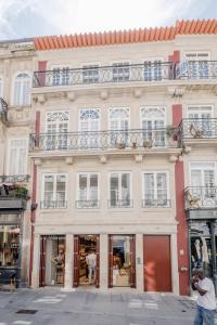 ポルトにあるBOUTIQUE Rentals-Flores Terrace historical centreの窓とバルコニー付きの白い大きな建物