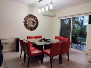 Villa Perfecta Zona Diamante في أكابولكو: غرفة طعام مع طاولة وكراسي ومرآة