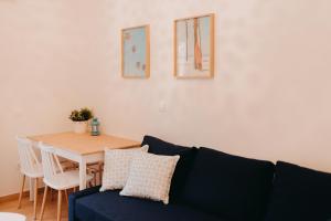 a living room with a blue couch and a table at the SummerHouse Project in Perítheia