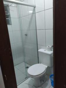 a white bathroom with a shower and a toilet at Hospedaria Ipiranga in São Paulo