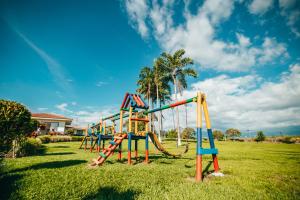 a playground in a grassy field with a slide at Hotel Arrayanes del Quindío in Montenegro