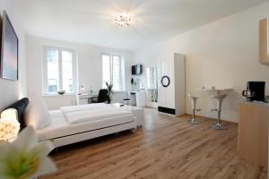 a living room with a white couch and wooden floors at Hotel Design Apart in Düsseldorf