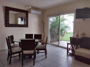 uma sala de jantar com uma mesa e cadeiras e uma janela em Casa Diamante en Zona Diamante em Acapulco