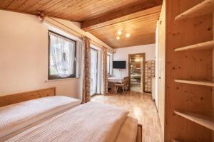 1 dormitorio con cama y escritorio en Residence Kronstein - Fewo 7, en Tesimo