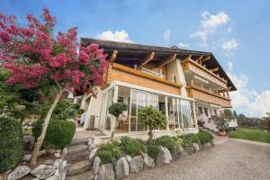 una casa con jardín y un árbol con flores rosas en Residence Kronstein - Fewo 7, en Tesimo