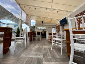 a dining room with white chairs and a table at Suites Arboleda 215 in Mexico City