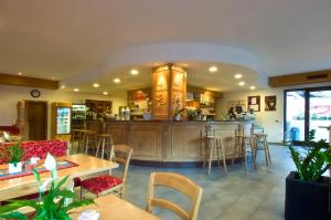 a restaurant with a bar and tables and chairs at Hotel Daniela in Merano