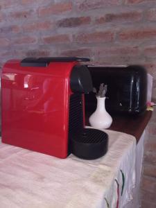 a red and black toaster sitting on top of a table at ROSALIMON in Nueva Palmira