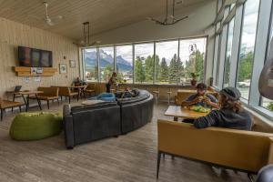 a lobby with people sitting on couches and tables at Canmore Downtown Hostel in Canmore