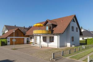 a house with a balcony with an umbrella on it at 1 Zimmer Ferienwohnung Baur Nr 2 in Salem