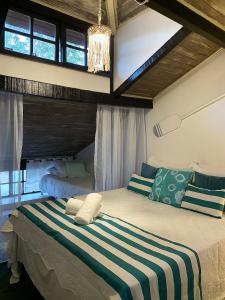 1 dormitorio con 1 cama grande con manta a rayas en Pousada Marittima, en Búzios