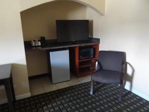 a room with a tv and a chair in a room at Budget Inn Columbus in Lockbourne