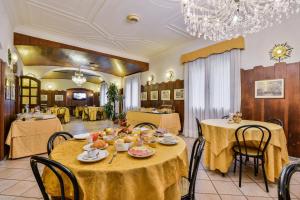 a dining room with tables and chairs and a chandelier at Hotel Don Abbondio in Lecco