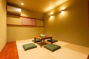 福岡市にあるSYA Hotel-上呉服町 一軒家貸し切りのテーブルと緑の椅子2脚が備わる客室です。