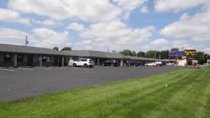 a parking lot with cars parked in front of a building at Budget Inn Columbus in Lockbourne